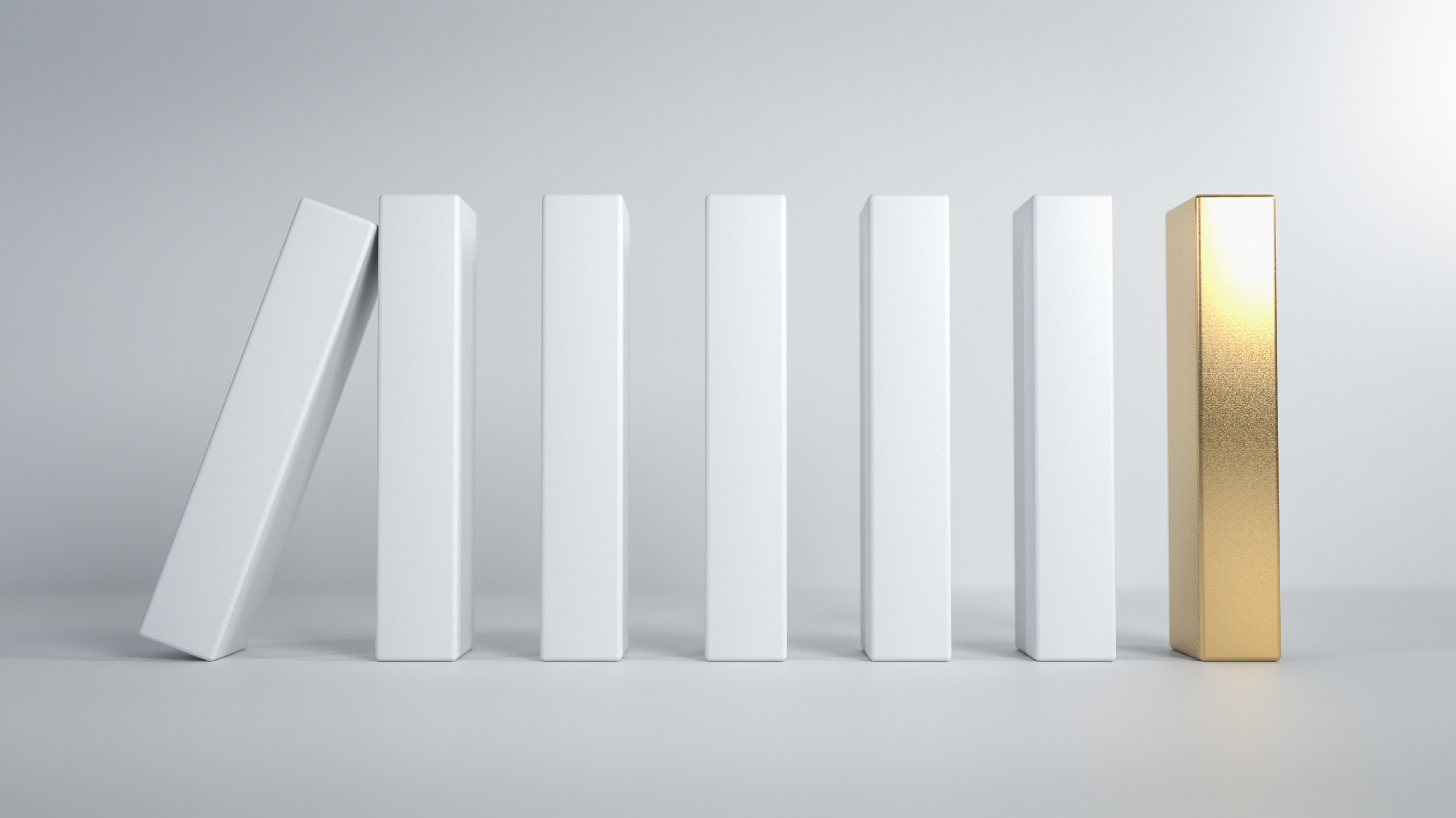 White dominoes standing in a row with one gold domino at the end and one white domino falling.