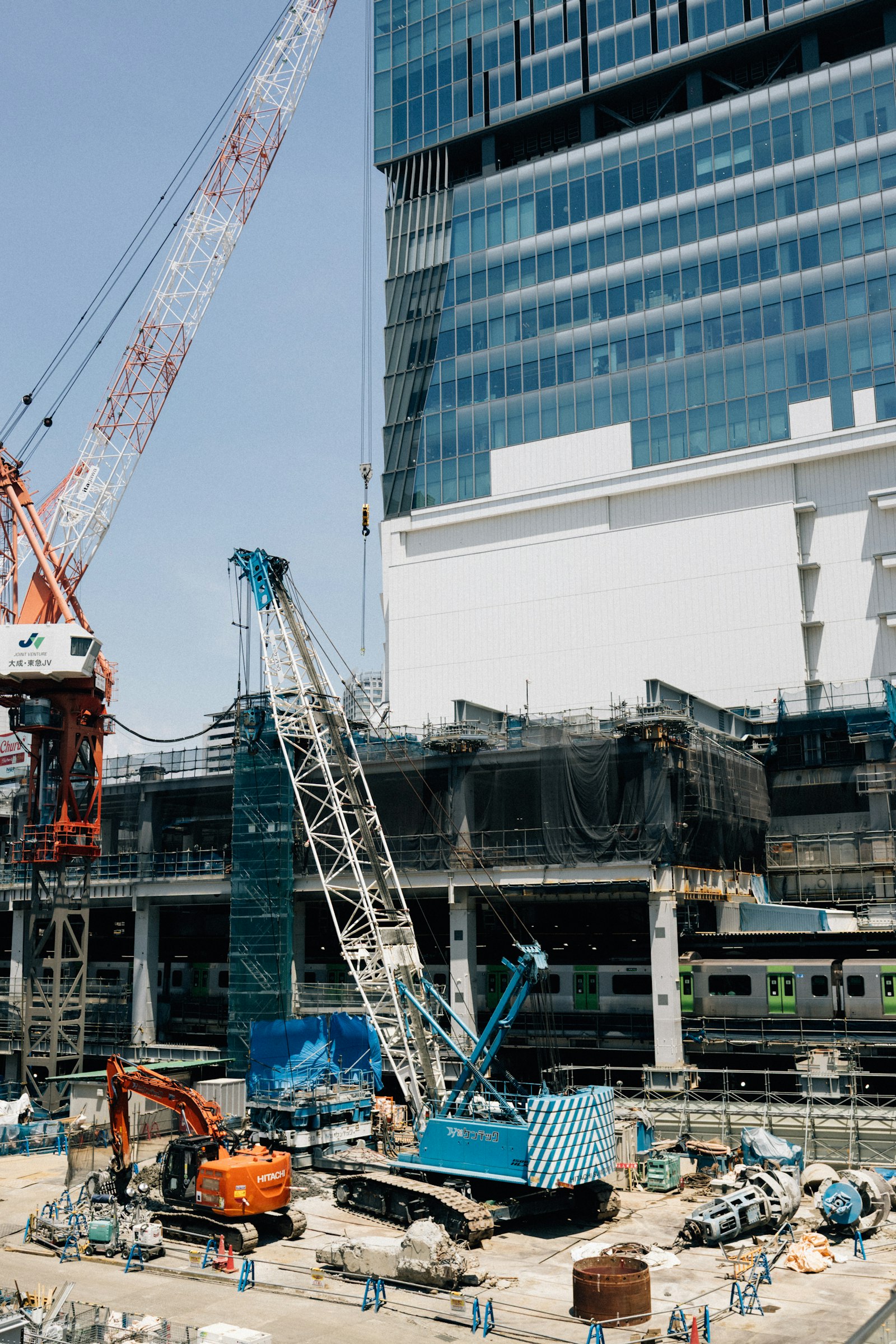 Construction site with tower cranes over a rising building