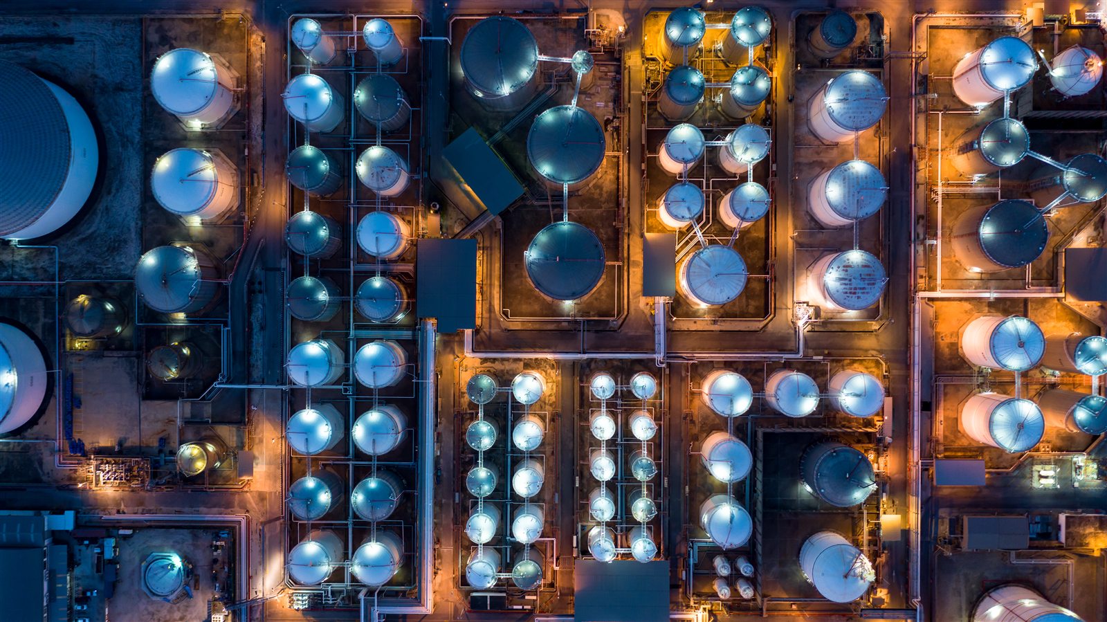 Aerial night view of an industrial plant with storage tanks and process units